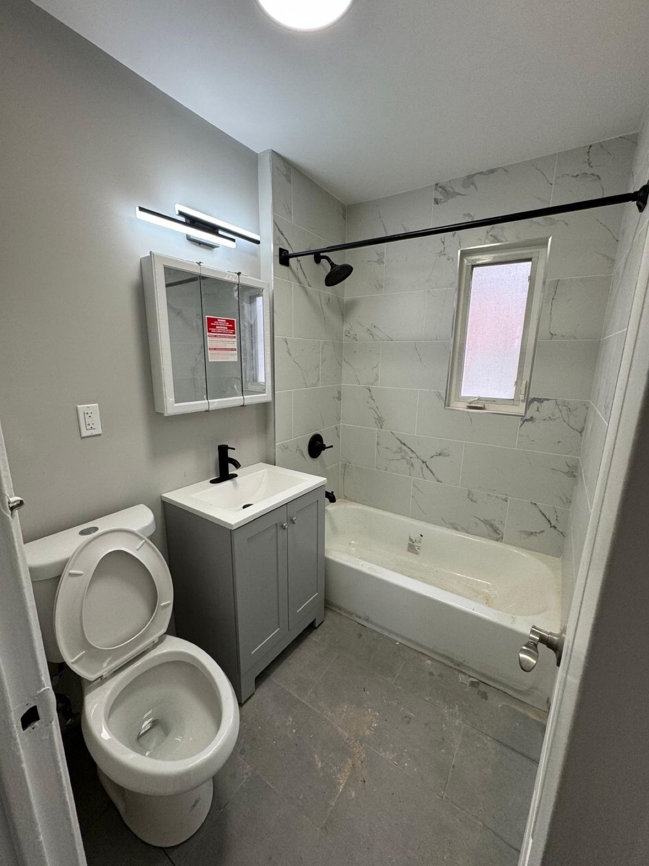 Baño con tocador gris y llaves de ducha negras