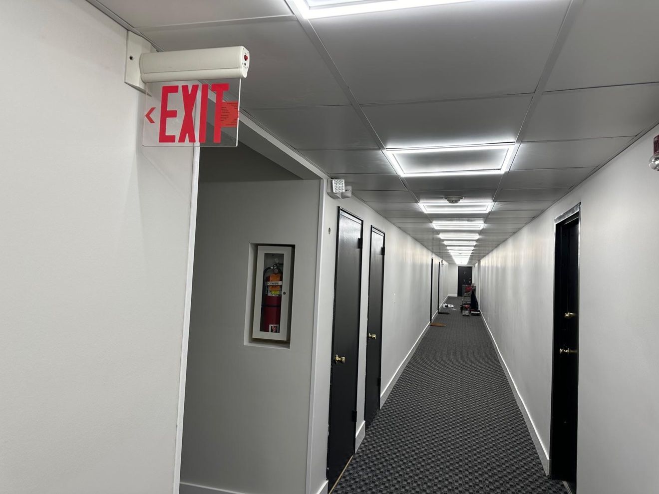 Pasillo comercial con letrero EXIT y alfombra nueva