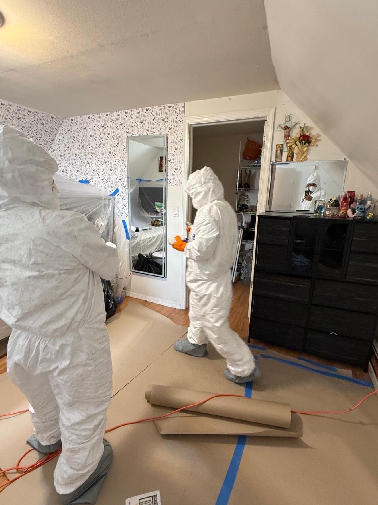 Equipo con trajes protectores preparando un dormitorio para la mitigación
