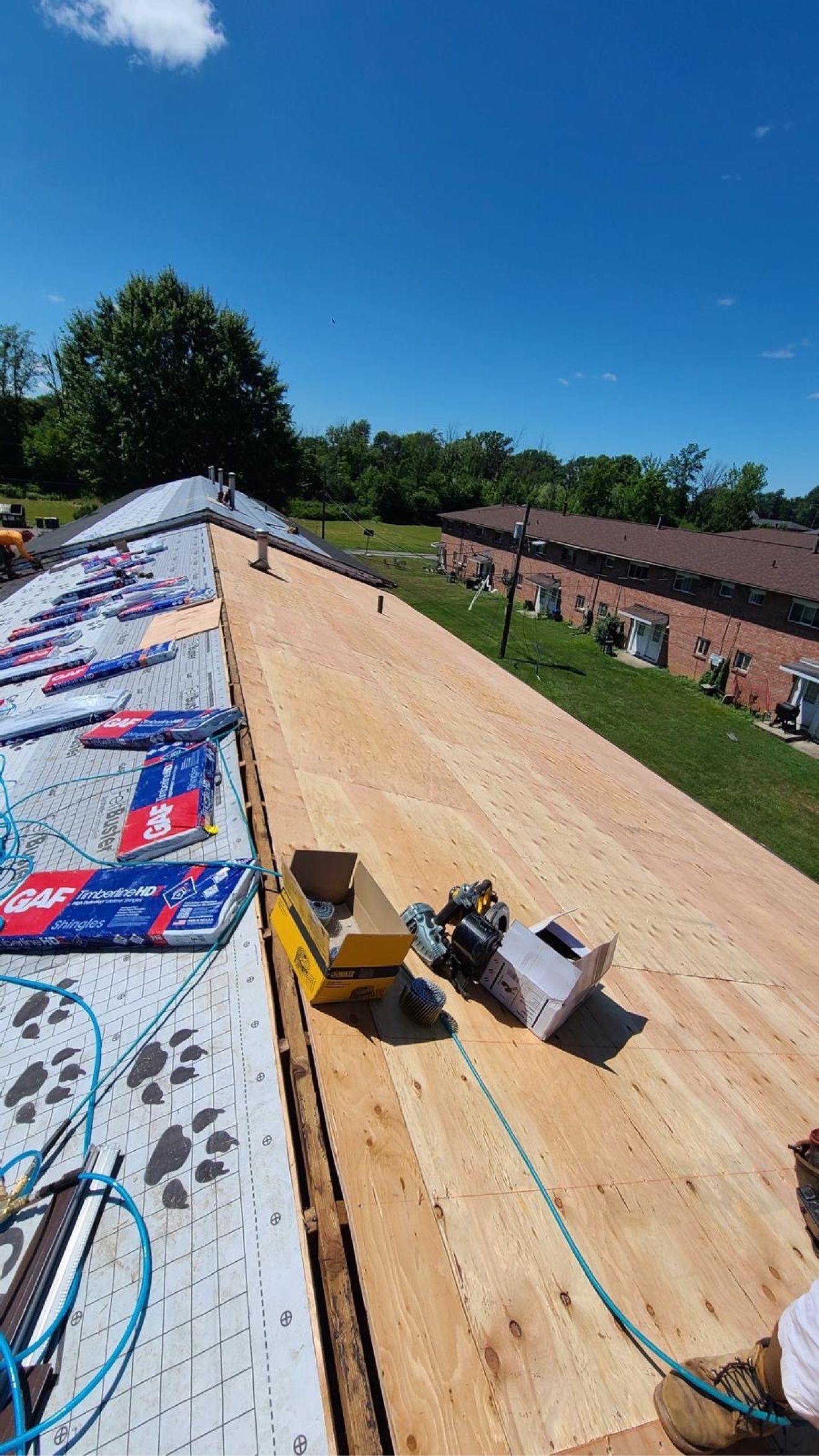 Plywood nuevo y paquetes de shingles GAF Timberline HD sobre un techo